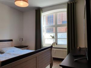 维斯马Nikolaikirch-Hof的一间卧室设有一张床和一个大窗户
