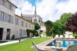 昂古莱姆Hotel Le Saint Gelais的一个带游泳池和大楼的庭院