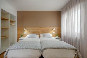 贝林Hostal-Restaurante LUGANO的一间卧室设有两张床和大窗户