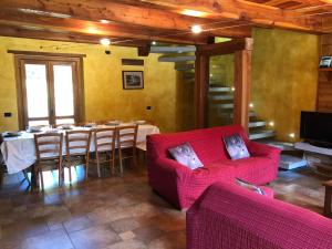 马斯诺维斯康蒂La Dolce Vita chalet的客厅配有桌子和红色沙发