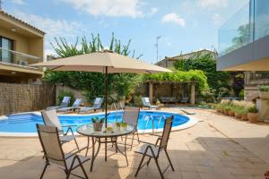 VilabertránCasa Deluxe Alt Empordà Costa Brava - Private swimming pool的庭院配有桌椅和遮阳伞。