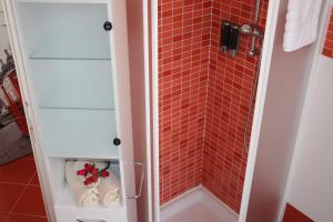 卡尔达诺阿尔坎波Le Margherite的一间铺有红色瓷砖的淋浴浴室