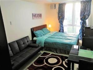 马尼拉Studio Condominium - Short and Long Term Staycation的一间卧室配有一张床、一张沙发和一个窗口