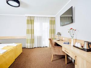 文克尼察穆扎可凯酒店的酒店客房配有书桌和床。