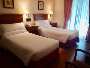圣塞瓦斯蒂安巴伊亚旅馆的酒店客房设有两张床和窗户。