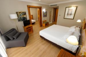 圣地亚哥－德孔波斯特拉Oca Puerta del Camino Hotel的一间卧室,卧室内配有一张床和一把椅子