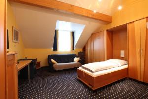 卢森堡奥普马克斯一室公寓酒店的一间卧室配有一张床、一把椅子和一张书桌