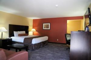 麦克明维尔麦克明维尔汽车旅馆的配有一张床和一把椅子的酒店客房