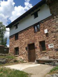 仕格莱Casa Soleta Ezcaray的一座石头建筑,设有棕色的门和窗户