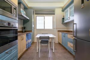 阿尔么丽亚El Rincón de Triana的厨房配有蓝色橱柜和桌椅