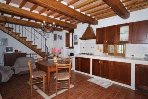 塞吉阿诺Agriturismo Ombianco的厨房以及带桌椅的用餐室。