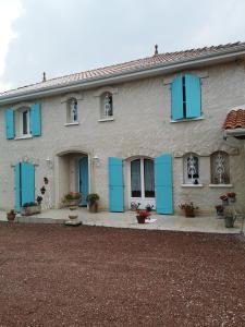 尚尼耶Chambre d’hôtes des tourterelles的一边有蓝色百叶窗的房子