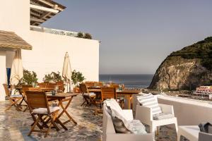 伊斯基亚Casa al Sole Boutique Hotel的一个带桌椅的庭院和大海