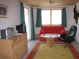 法莱拉Er Liung - Ferienwohnung für max. 3 Personen的客厅配有红色沙发和电视