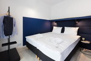 里沃Palicki - Apartamenty z widokiem na morze的一间卧室设有一张蓝色墙壁的大床
