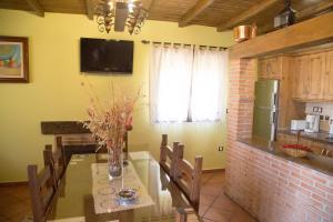 卡米诺新村Casas Rurales El Caminante的厨房配有一张桌子,上面放着花瓶