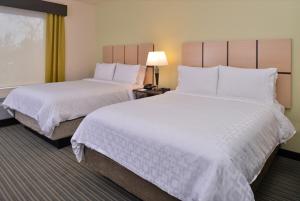 奥斯汀Candlewood Suites - Austin Airport, an IHG Hotel的酒店客房,配有两张带白色床单的床