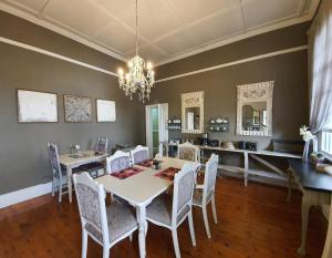 比勒陀利亚穆克伦纽克沃特豪斯山林小屋的一间带桌椅和吊灯的用餐室