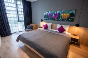 萨格勒布学术酒店的卧室配有一张带粉红色枕头的大床