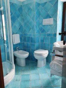 斯佩隆加Hotel Corallo Sperlonga的蓝色瓷砖浴室设有卫生间和水槽