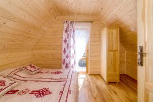 BańskaGÓRALOWE domki & SPA的木制客房内的一间卧室,配有一张床