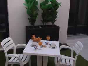 鲁瓦扬艾米丽酒店的一张带两把椅子的白色桌子和两杯橙汁