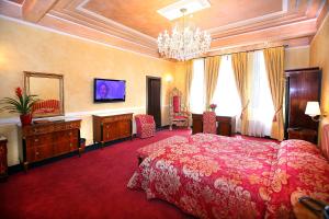 普洛耶什蒂维哥酒店的一间大卧室,配有一张红色的床和吊灯