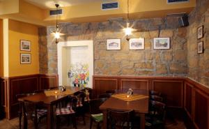 比尔森瓦利斯膳食旅馆的一间设有木桌和椅子的餐厅以及石墙