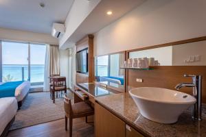名户Kariyushi LCH. Resort的酒店客房设有带水槽的浴室和一张床