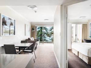悉尼快斯特曼利酒店的卧室配有一张床和一张桌子及椅子