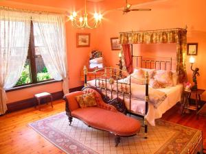 阿德莱德巴克斯顿庄园酒店的一间卧室配有一张床、一把椅子和一个吊灯。