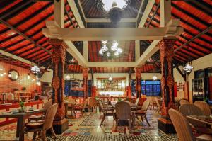 沙努尔阿里布德立酒店的一间带桌椅和吊灯的餐厅