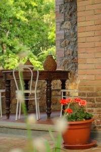 锡耶纳Villa Lilia by Let的桌子、两把椅子和一壶鲜花
