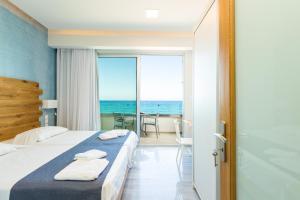 罗希姆诺Meltemi Coast Suites的一间卧室配有一张床,享有海景