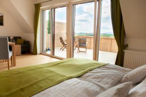莱布尼茨Weingut Assigal的一间卧室设有一张床,享有阳台的景色