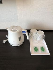 东京Ai Hotel Keikyu Kamata的烤面包机和桌子上的两个杯子