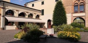 Cazzago San Martino欧雷布中心圣玛丽亚德尔阿尔科度假屋的庭院里种着树木和鲜花的建筑