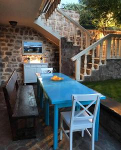 卢什蒂卡Villa Stella Rose的庭院设有楼梯,配有蓝色的桌椅