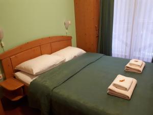 采尔克尼察Hotel Rakov Skocjan的一间卧室配有一张床,上面有两条毛巾