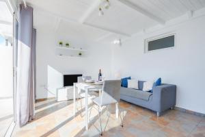 马赫Casa Amanecer 2的白色的客厅配有蓝色的沙发和桌子