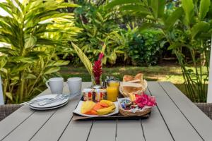 蒙舒瓦西蒙舒瓦西海滩度假公寓式酒店的桌上的食品托盘,包括水果和果汁