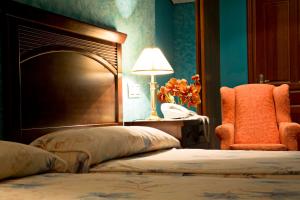 桑提亚纳德玛卡松萨洛杉矶骑士酒店的一间卧室配有一张床、一把椅子和一盏灯