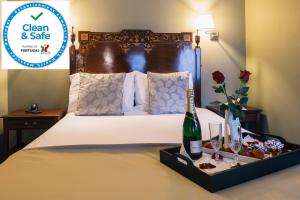 波尔图圣约斯酒店的酒店客房,配有一张带一瓶香槟的床