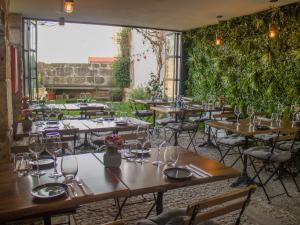 波尔图ALIBI by YoursPorto的餐厅设有木桌和椅子,种有植物