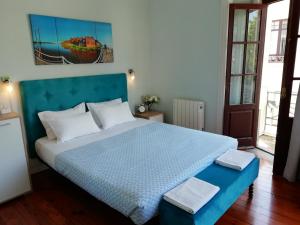 辛特拉阿祖尔旅舍的一间卧室配有一张大床和蓝色床头板