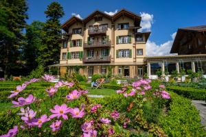 维尔德斯韦尔阿尔卑斯玫瑰酒店及花园的一座大建筑前面有鲜花