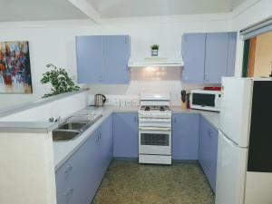 巴瑟尔顿Busselton Holiday Units的厨房配有蓝色橱柜和白色家电