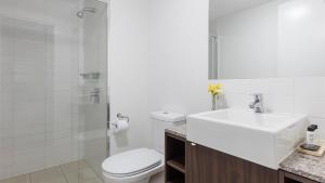 布里斯班Oaks Brisbane Aurora Suites的白色的浴室设有水槽和卫生间。