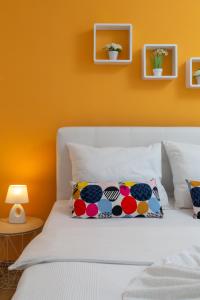 罗戈兹尼察Apartments Villa Zrinka的一间卧室配有一张白色的床和橙色的墙壁