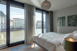 弗罗茨瓦夫EXCLUSIVE Aparthotel MARINA的一间卧室设有俯瞰河流的大窗户